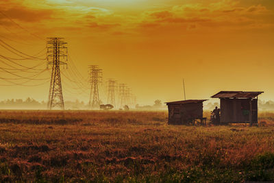 House on field against sky during sunset