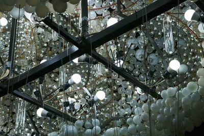 Low angle view of illuminated light bulbs hanging from ceiling