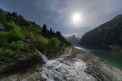 Scenic view of waterfall against sky