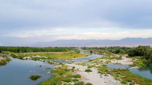 Scenic view of lake against cloudy sky