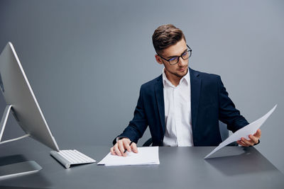 Young man using laptop while sitting on table