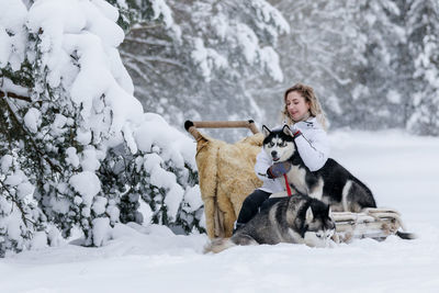 Woman with dogs on snow covered land