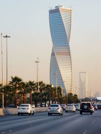 Traffic on road in city against clear sky