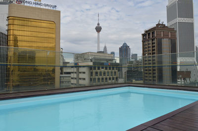 View of swimming pool against buildings in city