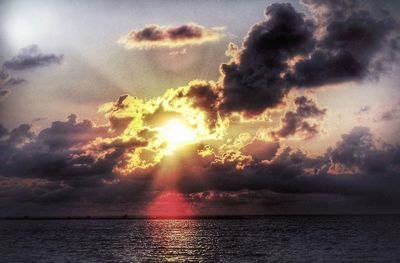 Scenic view of sea against cloudy sky at sunset