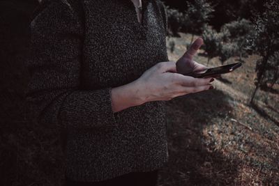 Midsection of woman using mobile phone