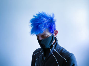 Portrait of young man against blue background