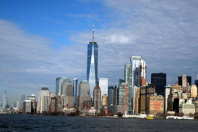 Modern buildings in city against cloudy sky