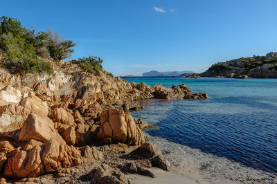 Rock formation on beach against sky