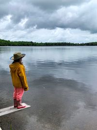 Rear view of woman in lake against sky
