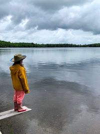 Rear view of woman in lake against sky