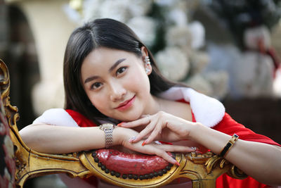 Portrait of smiling young woman sitting on chair