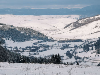 Scenic view of snow covered mountains against sky