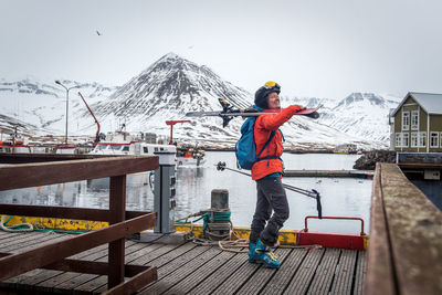 A woman laughing with skis on a dock in iceland