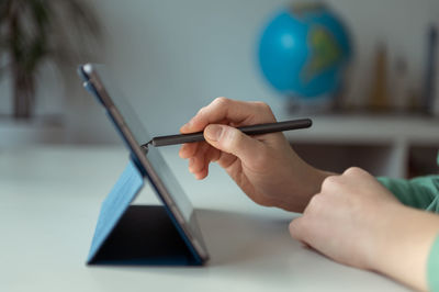 Cropped image of student using digital tablet