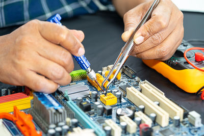 Cropped hands of man repairing circuit board