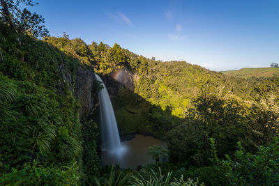 Scenic view of waterfall against sky