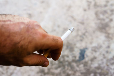 Close-up of hand holding cigarette