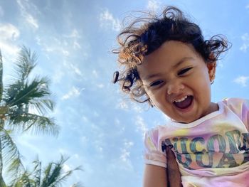 Portrait of smiling girl against blue sky