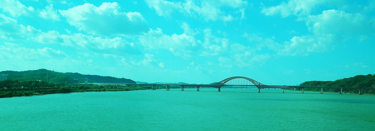 water, connection, architecture, sky, built structure, bridge - man made structure, waterfront, blue, river, cloud - sky, bridge, engineering, cloud, sea, tranquil scene, scenics, tranquility, nature, beauty in nature, transportation