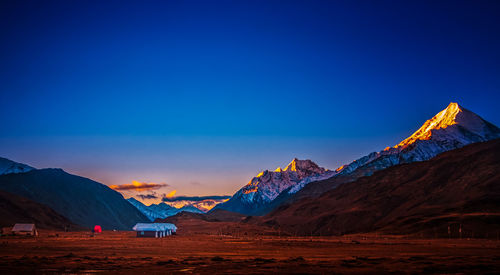 Scenic view of snowcapped mountains against clear blue sky