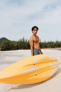 Shirtless man kayaking in sea