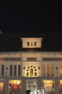 Low angle view of illuminated building against clear sky at night