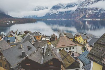 High angle view of buildings by lake against sky