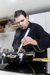 Man holding ice cream in kitchen