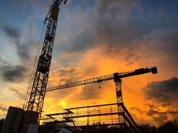Low angle view of crane at sunset