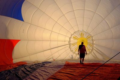 Rear view of man walking in hot air balloon