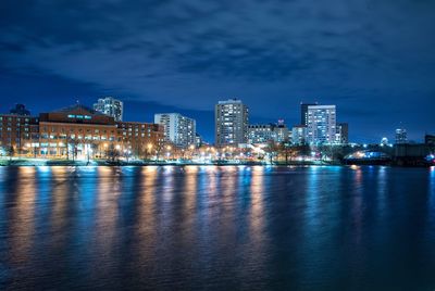 Lake and illuminated buildings against sky in city at night