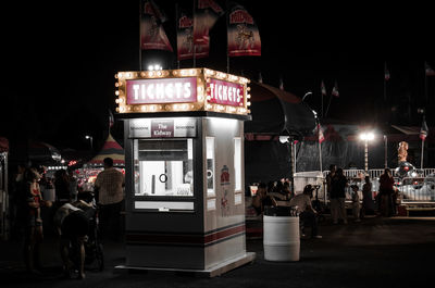 People on illuminated street at night