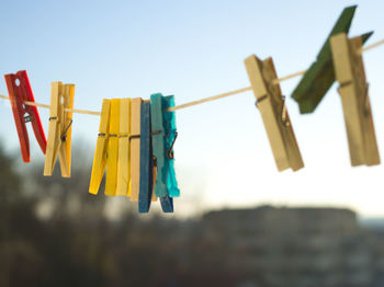 Close-up of clothespins hanging against sky