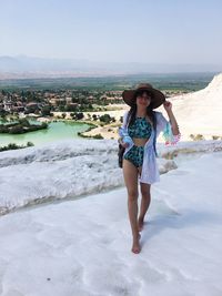 Full length of woman standing by sea against sky