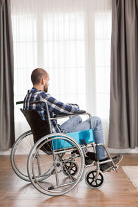 Disabled man sitting on wheelchair at home