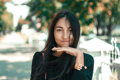 Portrait of young woman with long hair standing outdoors