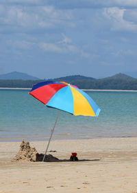 Umbrella on beach against sky