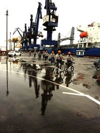 Reflection of people on boat in city against clear sky