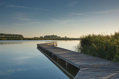 Pier over lake against sky