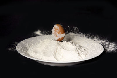 Close-up of ice cream in bowl against black background