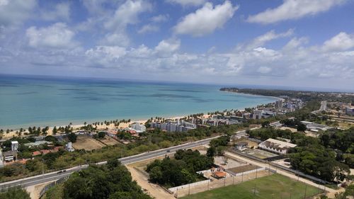 High angle view of cityscape by sea against sky