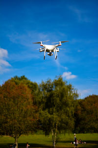 Low angle view of airplane flying against blue sky