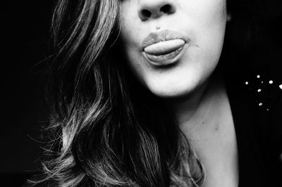 Cropped image of woman sticking out tongue