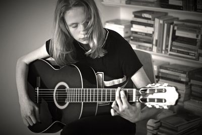 Close up of woman playing guitar at home