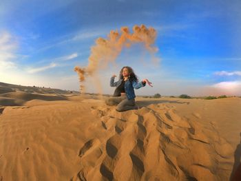 Woman playing with sands at desert