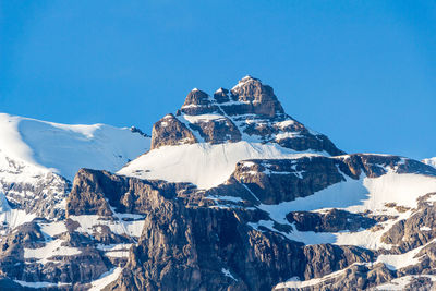 Scenic view of snowcapped mountains against clear blue sky