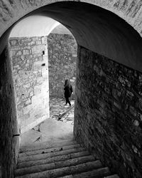 Rear view of woman walking in tunnel