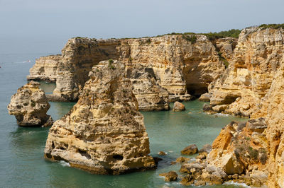 Rock formations by sea against sky