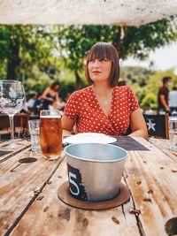 Woman looking away while sitting by table at restaurant